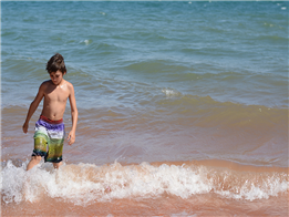 Cậu bé đi bộ trên bãi biển
